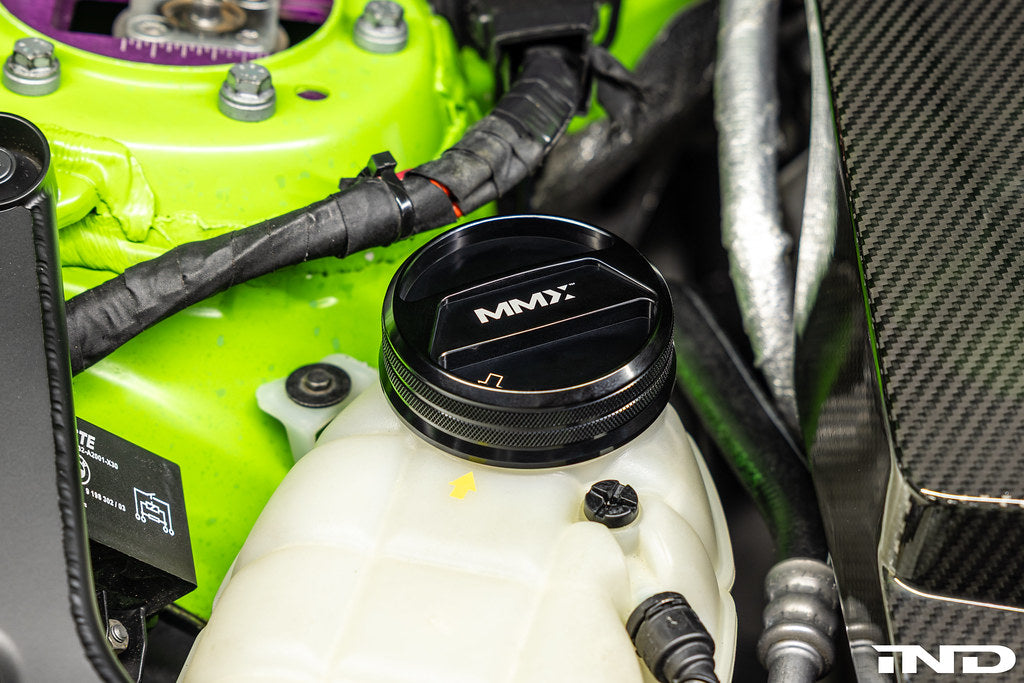 MMX Performance BMW billet coolant expansion cap installed on engine, showcasing high-quality performance engine part.