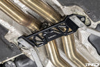 MMX Performance Underbody Chassis Brace installed on a BMW F8X M2, M2 Competition, M3, or M4, providing an additional 15mm of exhaust clearance while maintaining factory ground clearance and increasing chassis rigidity.