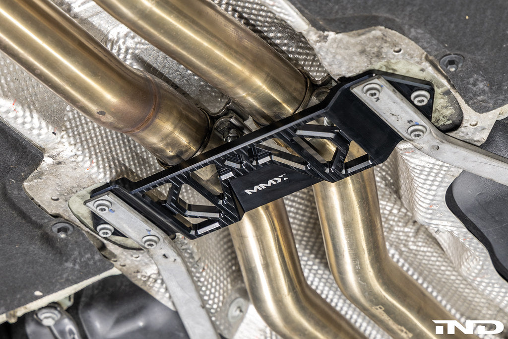 MMX Performance Underbody Chassis Brace installed on a BMW F8X M2, M2 Competition, M3, or M4, providing an additional 15mm of exhaust clearance while maintaining factory ground clearance and increasing chassis rigidity.