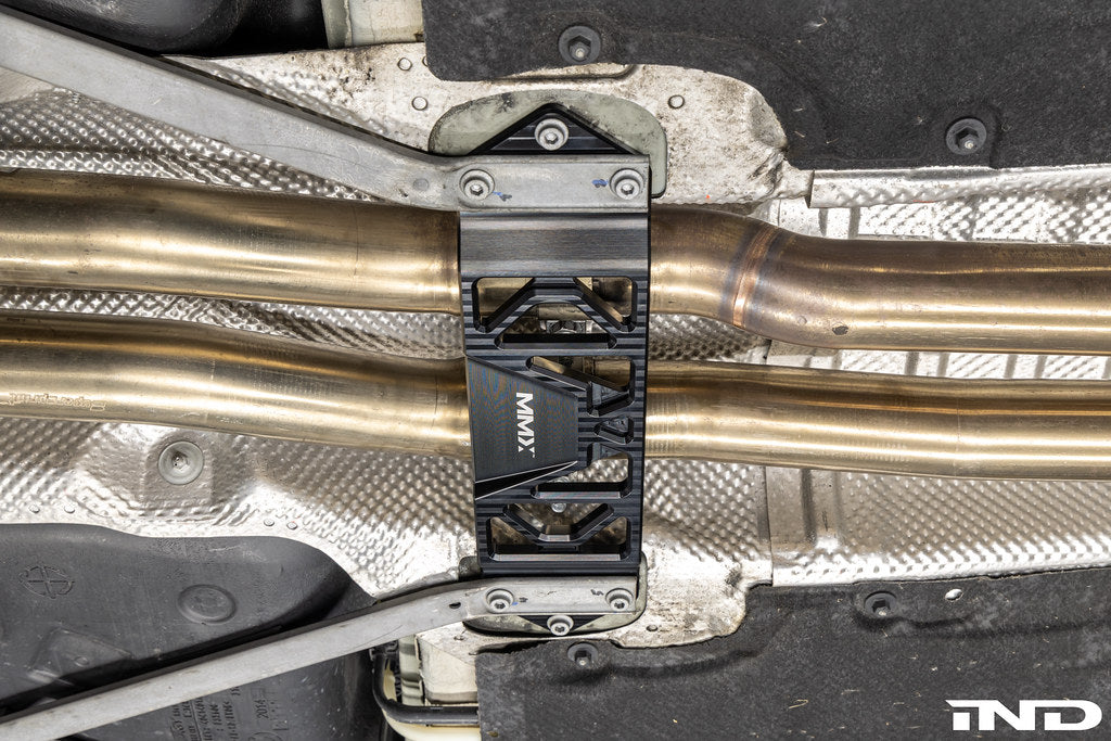 MMX Performance Underbody Chassis Brace installed on a BMW F8X M2, M2 Competition, M3, or M4, providing an additional 15mm of exhaust clearance while maintaining factory ground clearance and increasing chassis rigidity.