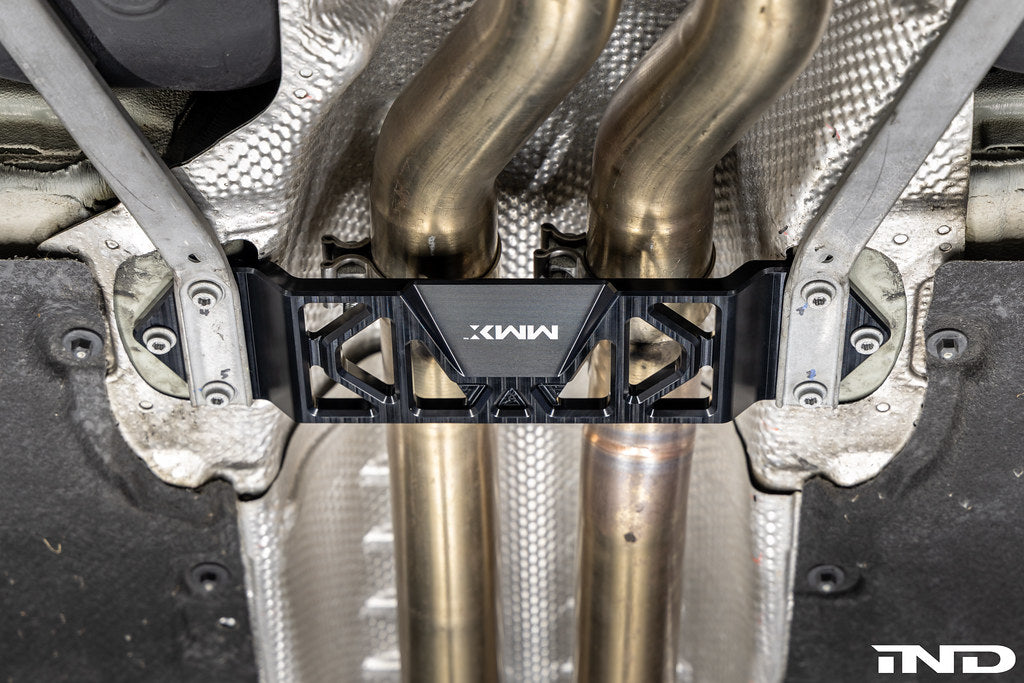 MMX Performance Underbody Chassis Brace installed on a BMW F8X M2, M2 Competition, M3, or M4, providing an additional 15mm of exhaust clearance while maintaining factory ground clearance and increasing chassis rigidity.