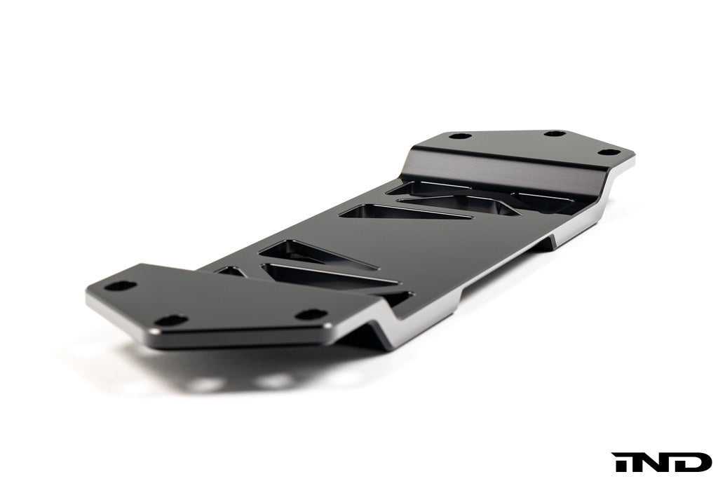 MMX Performance BMW F8X Underbody Chassis Brace on a white background, precision CNC machined from billet 6061-T6 aluminum to increase exhaust clearance, improve chassis rigidity, and provide a direct OEM-fit installation for the F87 M2, M2 Competition, F80 M3, and F82/F83 M4.