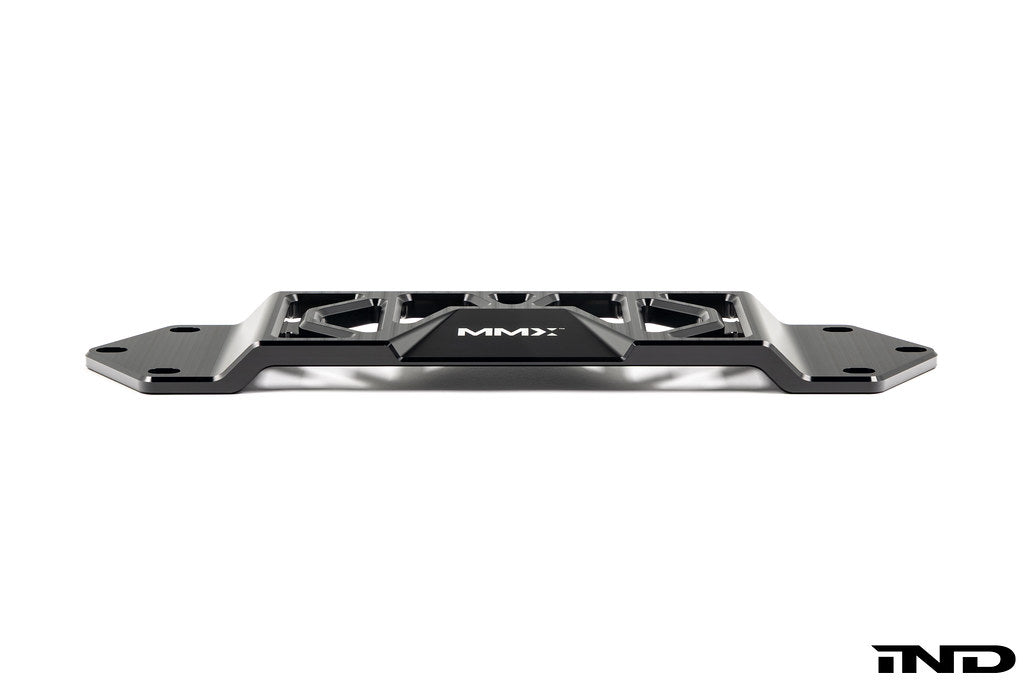 MMX Performance BMW F8X Underbody Chassis Brace on a white background, precision CNC machined from billet 6061-T6 aluminum to increase exhaust clearance, improve chassis rigidity, and provide a direct OEM-fit installation for the F87 M2, M2 Competition, F80 M3, and F82/F83 M4.
