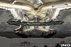 MMX Performance BMW G87 M2 Underbody Chassis Brace installed, providing an additional 15mm of exhaust clearance while maintaining factory ground clearance and increasing chassis rigidity with a precision billet 6061-T6 aluminum design.