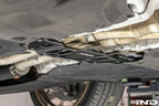 MMX Performance BMW G87 M2 Underbody Chassis Brace installed, providing an additional 15mm of exhaust clearance while maintaining factory ground clearance and increasing chassis rigidity with a precision billet 6061-T6 aluminum design.
