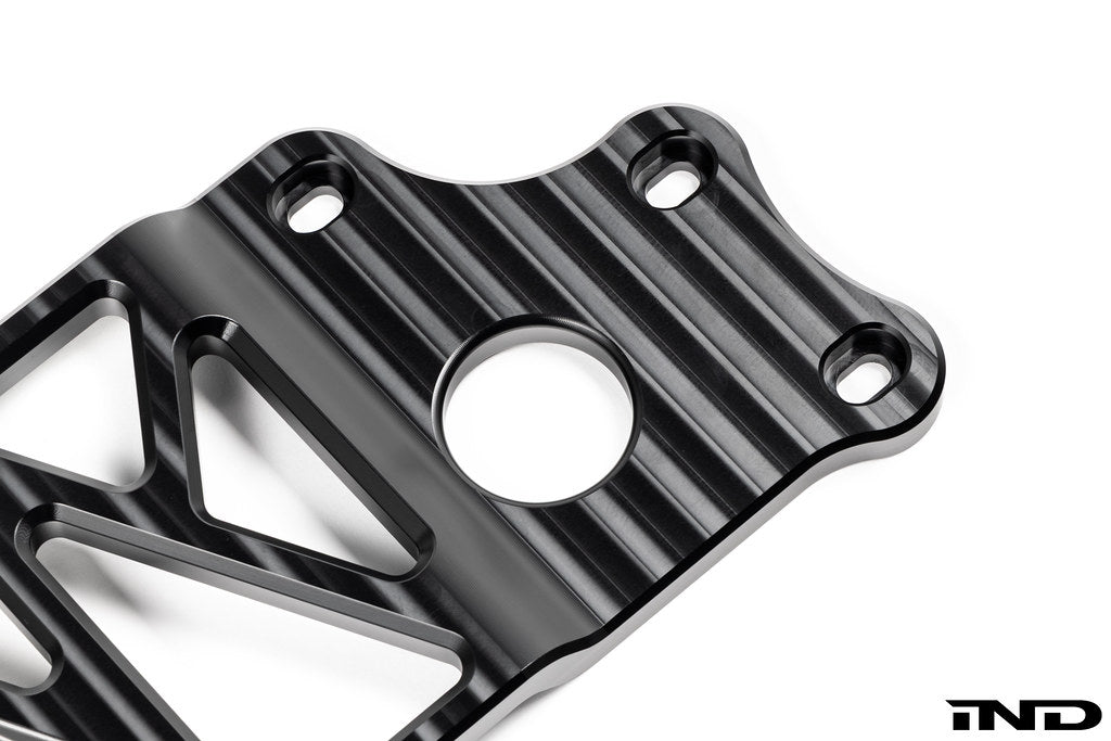 MMX Performance BMW G87 M2 Underbody Chassis Brace on a white background, precision CNC machined from billet 6061-T6 aluminum to provide additional exhaust clearance, increased chassis rigidity, and direct OEM-fit installation.