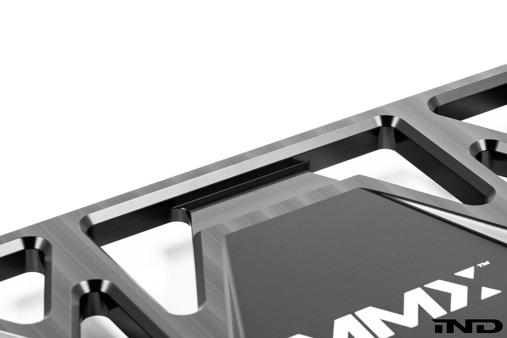 MMX Performance BMW G87 M2 Underbody Chassis Brace on a white background, precision CNC machined from billet 6061-T6 aluminum to provide additional exhaust clearance, increased chassis rigidity, and direct OEM-fit installation.