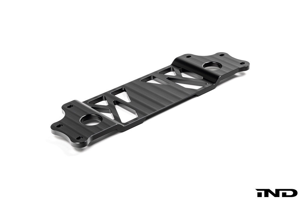 MMX Performance BMW G87 M2 Underbody Chassis Brace on a white background, precision CNC machined from billet 6061-T6 aluminum to provide additional exhaust clearance, increased chassis rigidity, and direct OEM-fit installation.