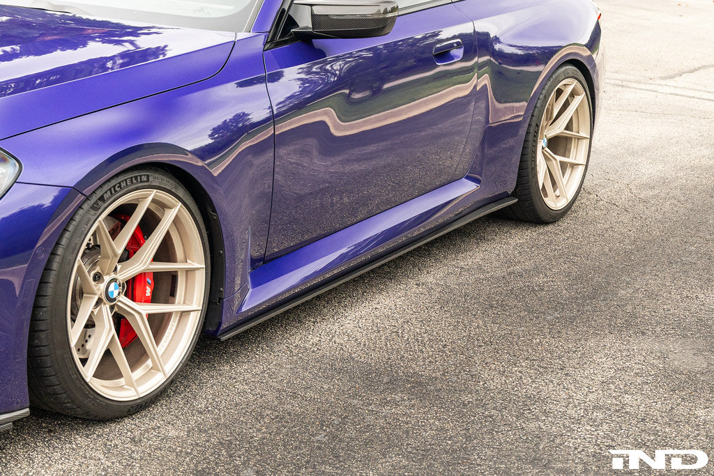 TREVORA carbon flat side skirts installed on a BMW G87 M2