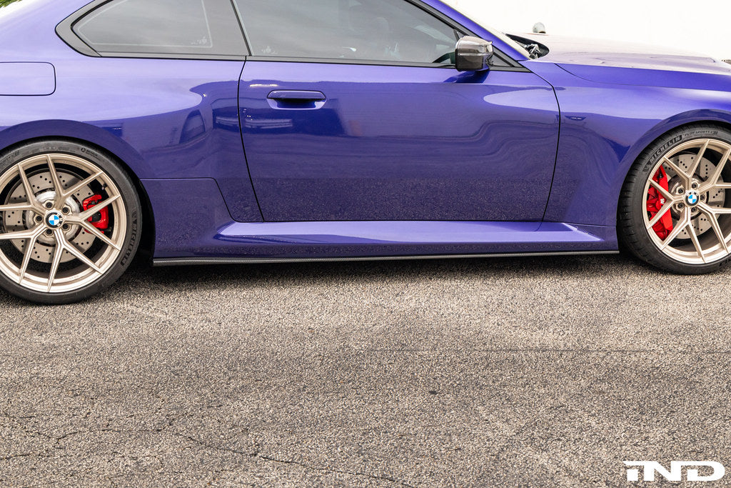 TREVORA carbon flat side skirts installed on a BMW G87 M2