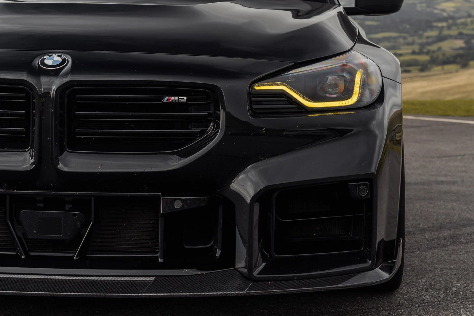TREVORA G87 M2 carbon front splitter with winglets installed on a BMW M2 exterior showing detailed aerodynamic components.