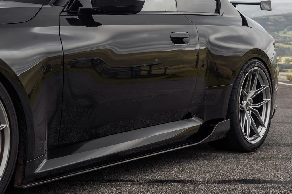 TREVORA G87 M2 Carbon side skirt set installed on a car, showcasing sleek exterior design and aerodynamic features.