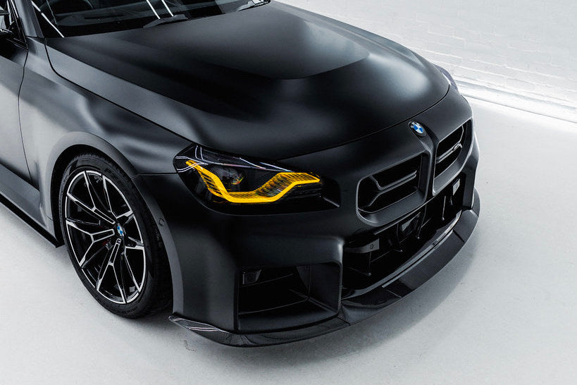 TREVORA G87 M2 TR87 carbon flat front splitter installed on the exterior of a vehicle, showcasing its sleek aerodynamic design.