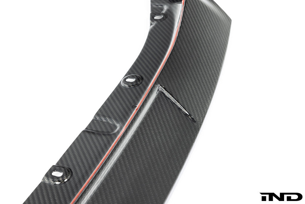 TREVORA G87 M2 TR87 carbon flat front splitter mounted on a car's white exterior, enhancing aerodynamics and sporty appearance.