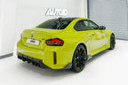 TREVORA G87 M2 Carbon rear bumper winglet set installed on exterior of BMW M2, showcasing sleek aerodynamic design.