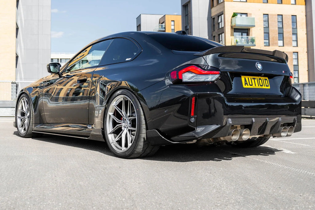 TREVORA G87 M2 Carbon rear bumper winglet set installed on car exterior, highlighting sleek aerodynamic design and carbon fiber finish.