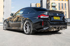TREVORA G87 M2 Carbon rear bumper winglet set installed on car exterior, highlighting sleek aerodynamic design and carbon fiber finish.