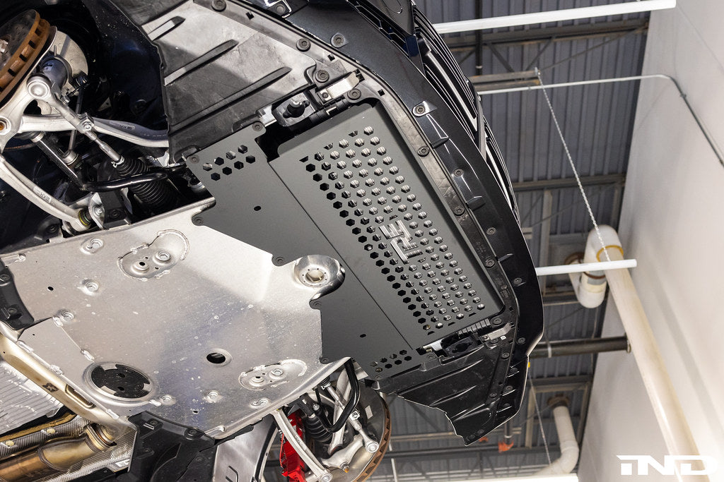 TREVORA G8X M2 M3 M4 metal skid plate and arch clearance kit installed on the vehicle's exterior underside.