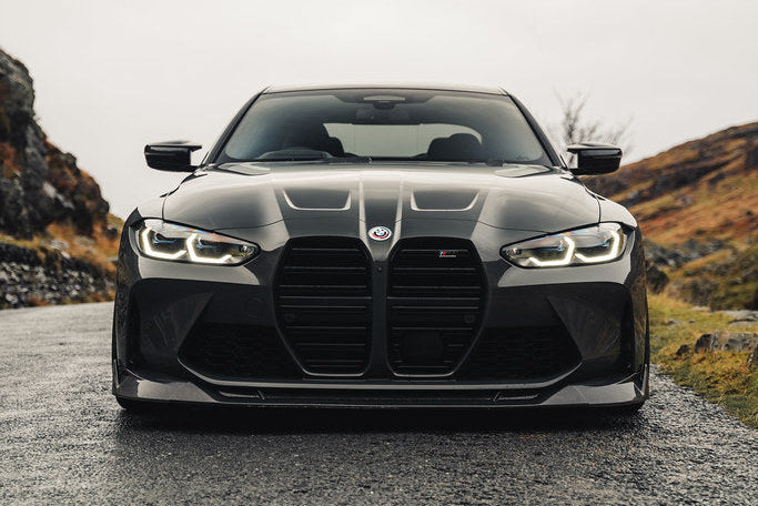 TREVORA G8X M3 M4 carbon fiber front splitter installed on vehicle, showcasing sleek exterior design and aerodynamic enhancement.