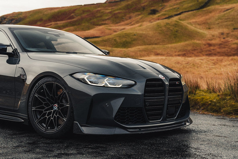 TREVORA G8X M3 M4 carbon fiber front splitter installed on vehicle, showcasing sleek exterior design and aerodynamic enhancement.