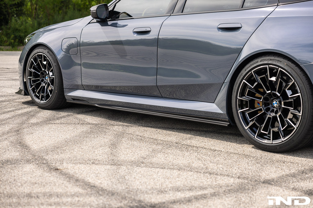 TREVORA BMW G90 G99 M5 PR-1 Carbon side skirts installed on the exterior of the vehicle.