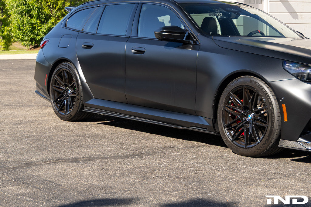 TREVORA G90 G99 M5 carbon fiber PR-1 side skirts installed on a vehicle, showcasing sleek exterior automotive styling.
