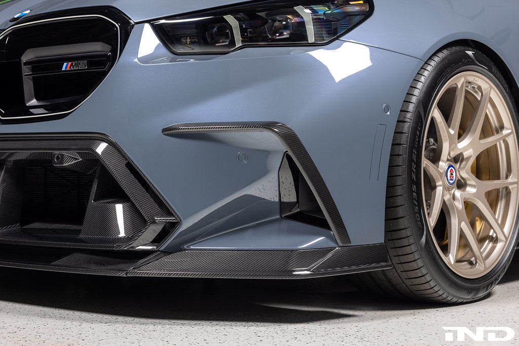 TREVORA G90 G99 M5 carbon fiber front duct extension trims installed on exterior of vehicle, showcasing sleek, aerodynamic design.