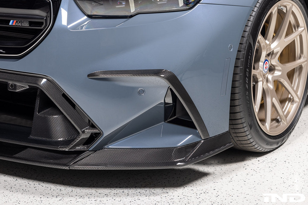 TREVORA G90 G99 M5 carbon fiber front duct extension trims installed on vehicle exterior for enhanced aerodynamics.