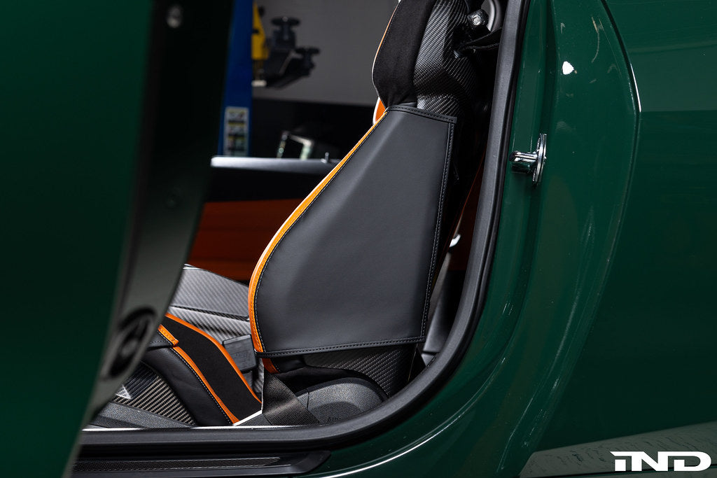 Wunderworks BMW M Carbon bucket seat upper bolster protector set installed in car interior, featuring black carbon fiber material.
