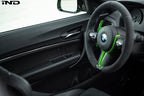 Interior view of Alpha N F87 M2 Carbon Door Card Set installed, showcasing sleek carbon fiber finish on vehicle door panels.