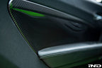 Alpha N F87 M2 carbon interior door card set installed in a vehicle, showcasing sleek black carbon fiber finish.