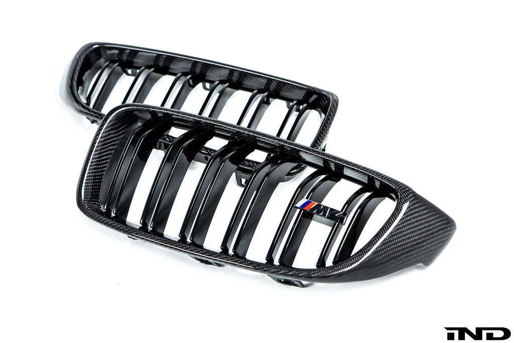 IND Carbon Fiber Front Grille Set for BMW F80 M3 and F82/F83 M4 featuring 2x2 carbon fiber surrounds with OEM BMW grille slats on a white background.