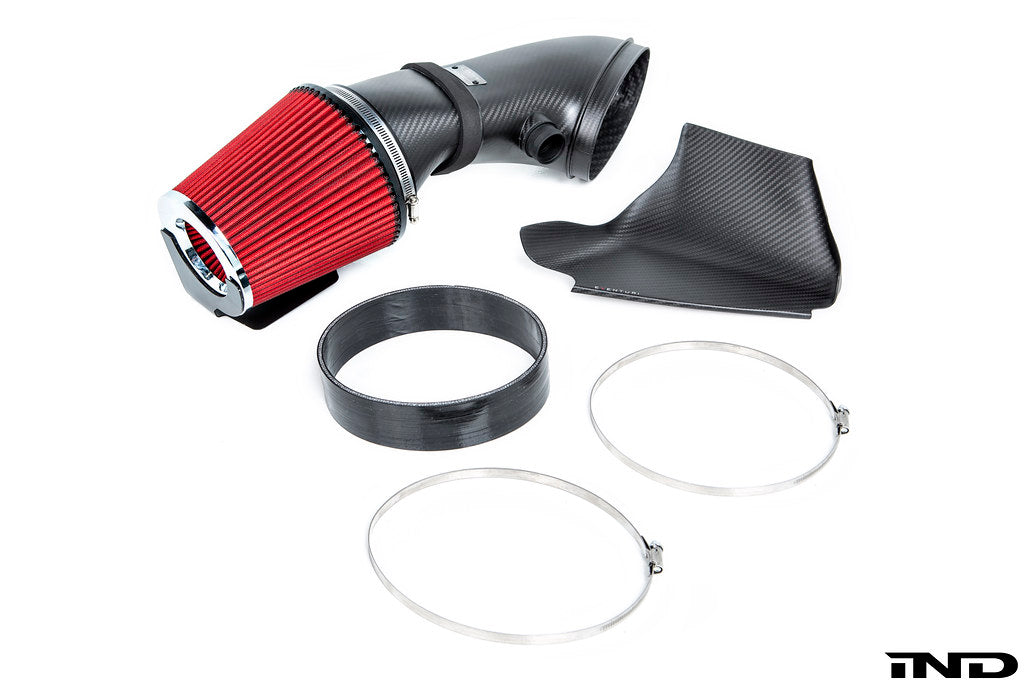 Component view of a disassembled Eventuri BMW E9X M3 Black Carbon Intake System, including the carbon fibre intake tube, high flow urethane cone filter, carbon fibre inlet scoop, silicon coupler, and clamps on a white background.