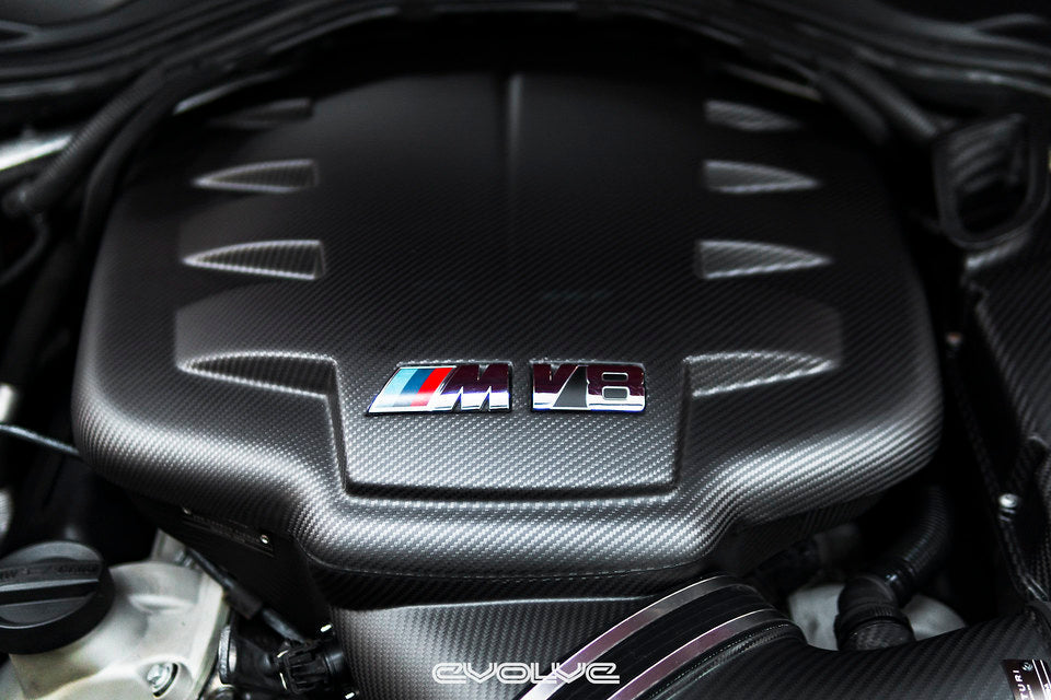 Front view of Eventuri black carbon fiber inlet plenum in matte finish installed in BMW E9X M3 engine bay