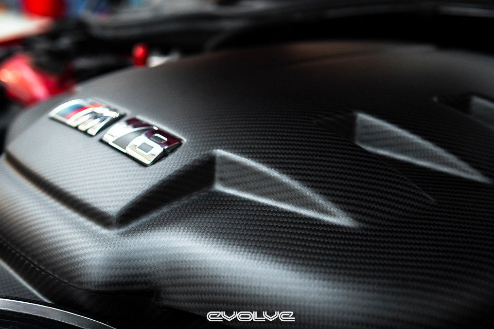 Close-up right 3/4 front view of Eventuri black carbon fiber inlet plenum in matte finish installed in BMW E9X M3 engine bay