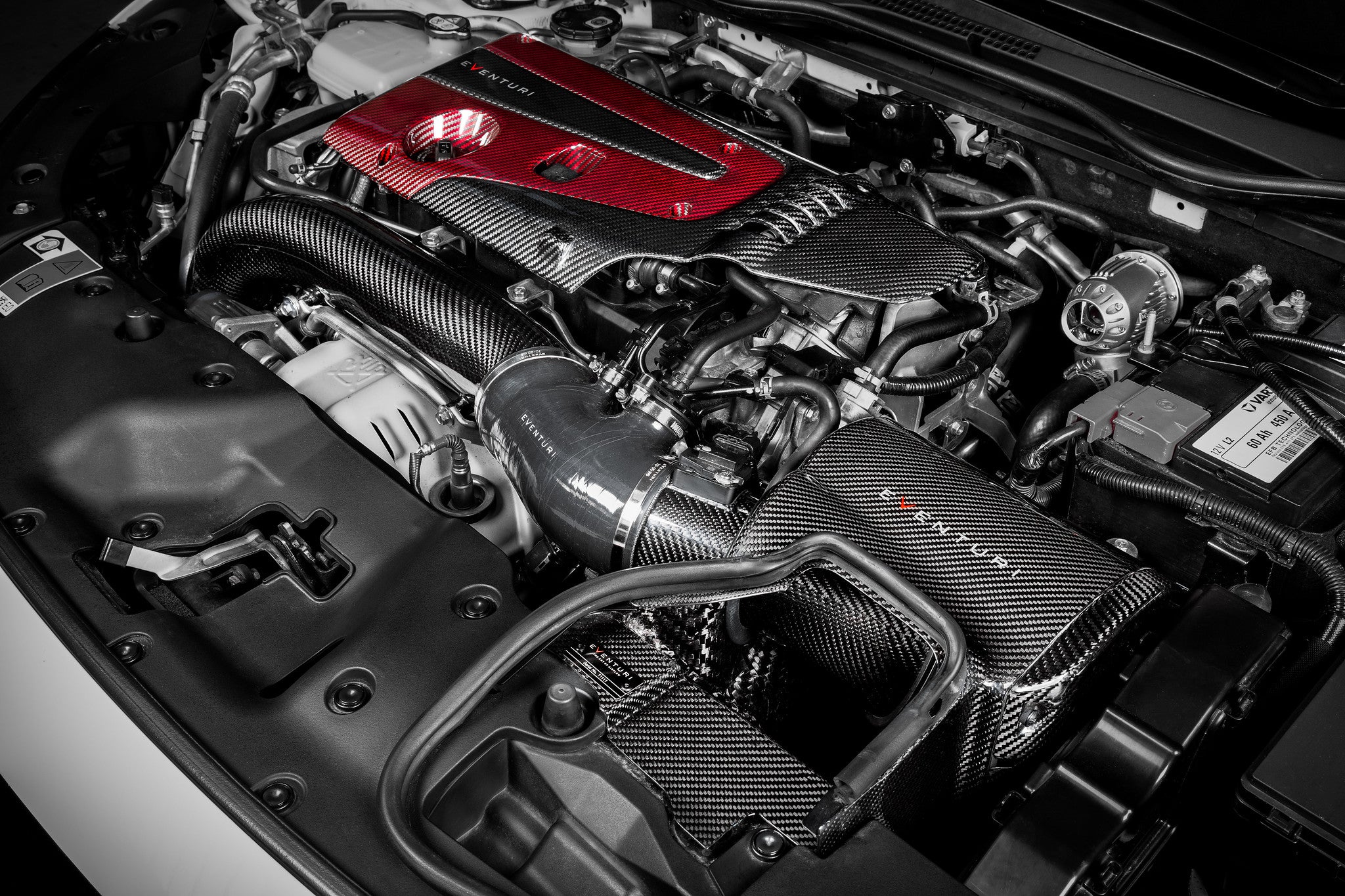 Front 3/4 view of an FK8 Civic Type-R engine bay showing the Eventuri carbon intake system installed.