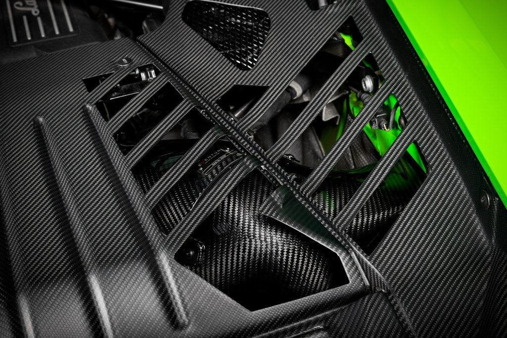 Close-up of black carbon engine cover set by Eventuri on a Lamborghini Huracan, showcasing performance-oriented design and fitment.