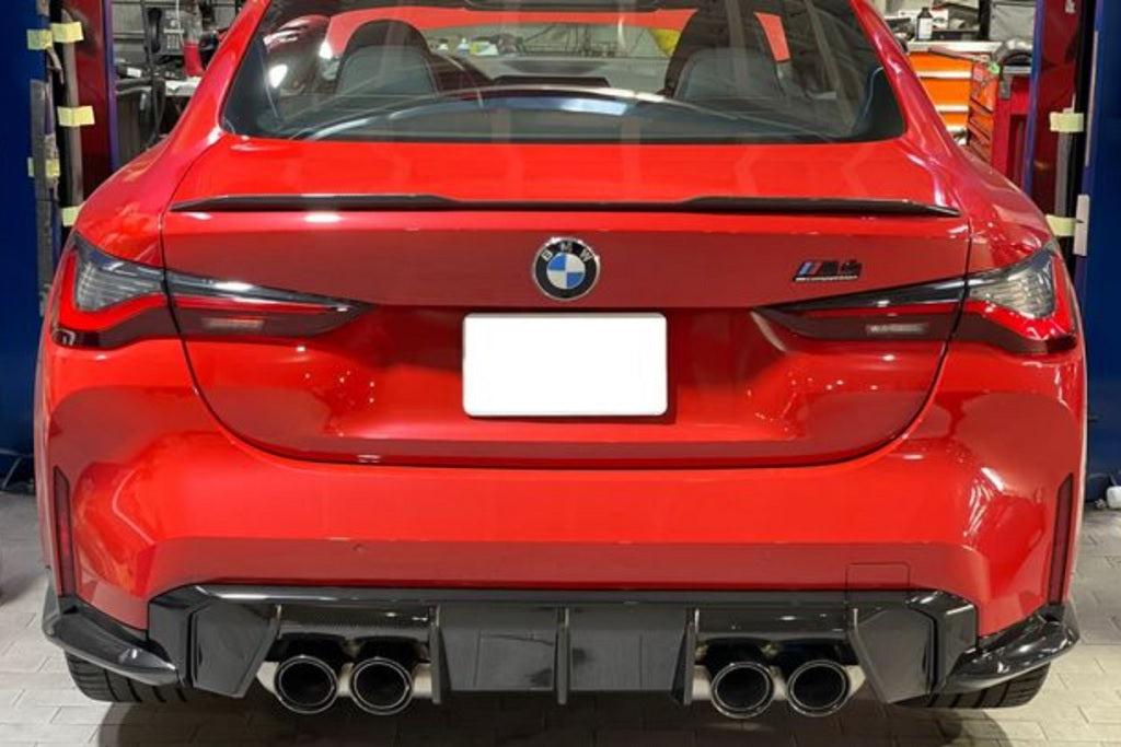 BMW M Performance G8X M3/M4 carbon rear diffuser showcased on a sleek vehicle, highlighting its aerodynamic design.
