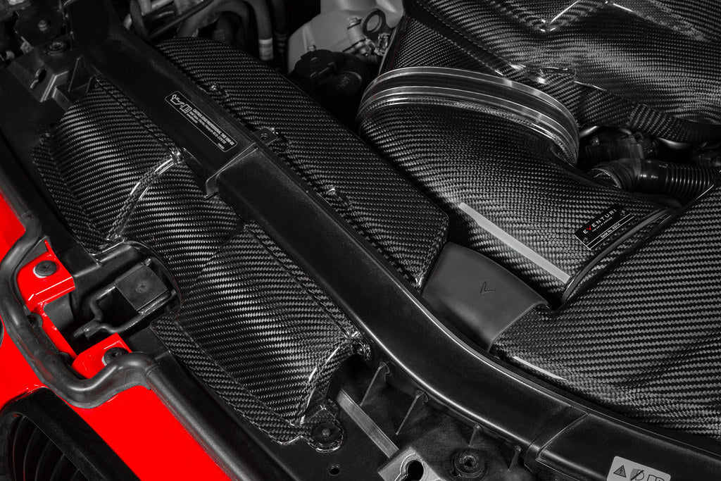 Eventuri gloss carbon fiber duct set installed in the engine bay of a red BMW E92 M3 Coupe