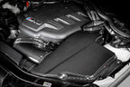 Eventuri black carbon airbox lid installed on BMW E9X M3 S65 engine for enhanced performance and sleek gloss finish.