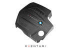 Overhead front view of black carbon BMW F-Chassis N55 engine cover by Eventuri, showcasing its sleek performance design.