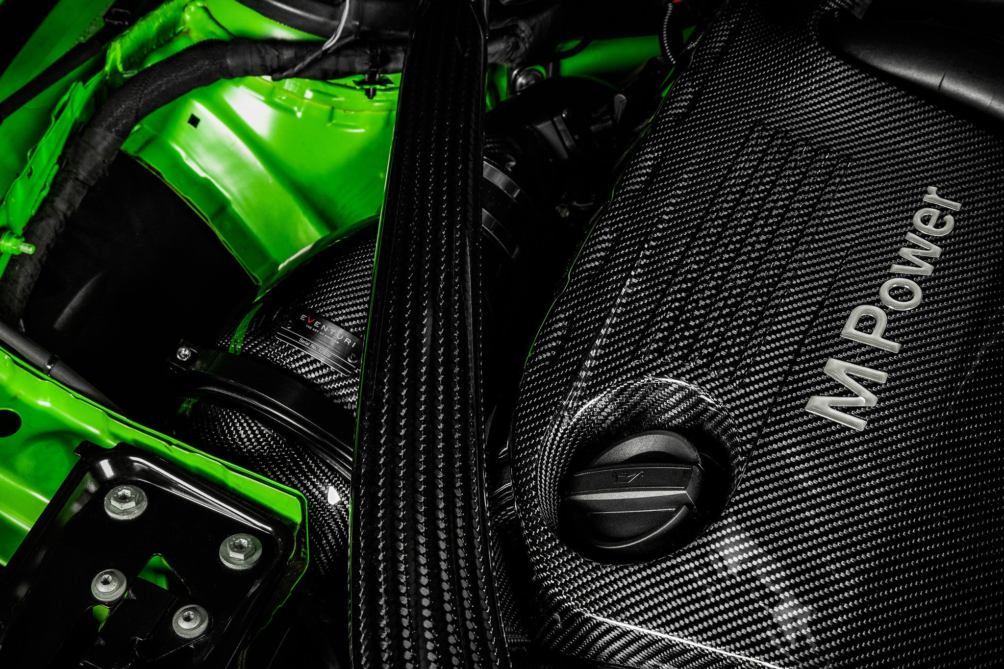 Eventuri black carbon intake system installed in engine bay of BMW F8X M3 and M4 with V2 performance upgrade.