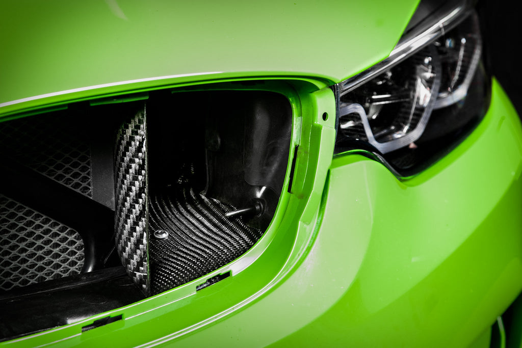 Eventuri black carbon intake system installed in engine bay of BMW F8X M3 and M4 S55 performance vehicle.