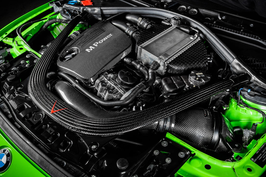 Eventuri black carbon intake system installed in BMW F8X M3 and M4 engine bay, showcasing performance air intake upgrade.