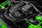 Eventuri black carbon intake system installed in BMW F8X M3 and M4 engine bay, showcasing performance air intake upgrade.