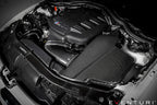 Eventuri black carbon airbox lid for BMW E9X M3 S65 engine bay, glossy performance air intake component.